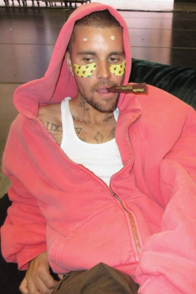 Justin Bieber holding a lip treatment in mouth