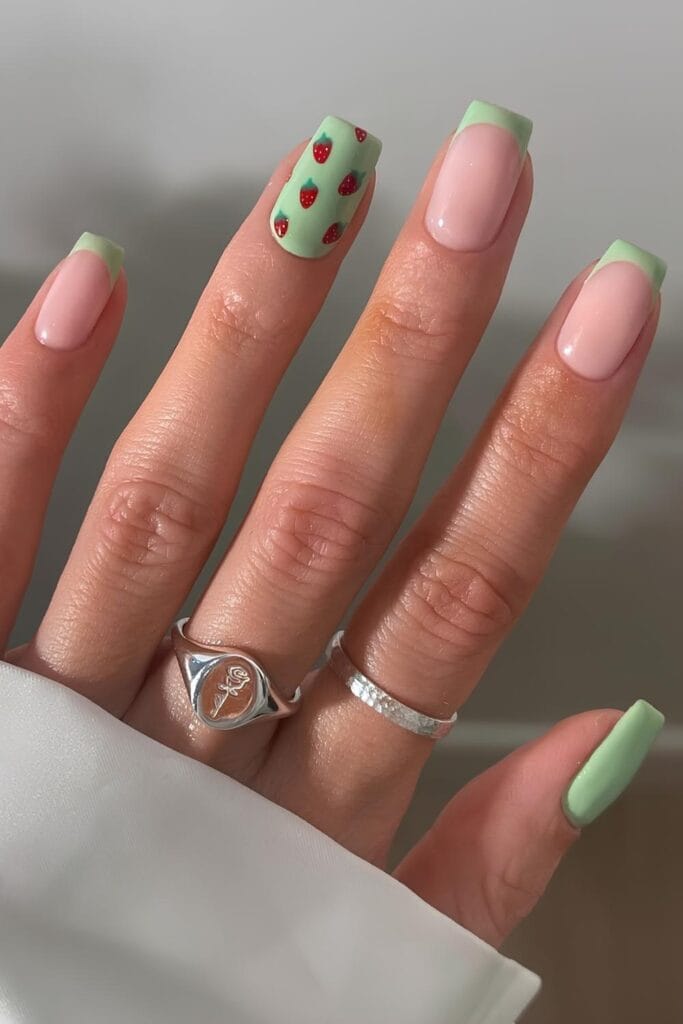 Light green French mani with strawberry accents
