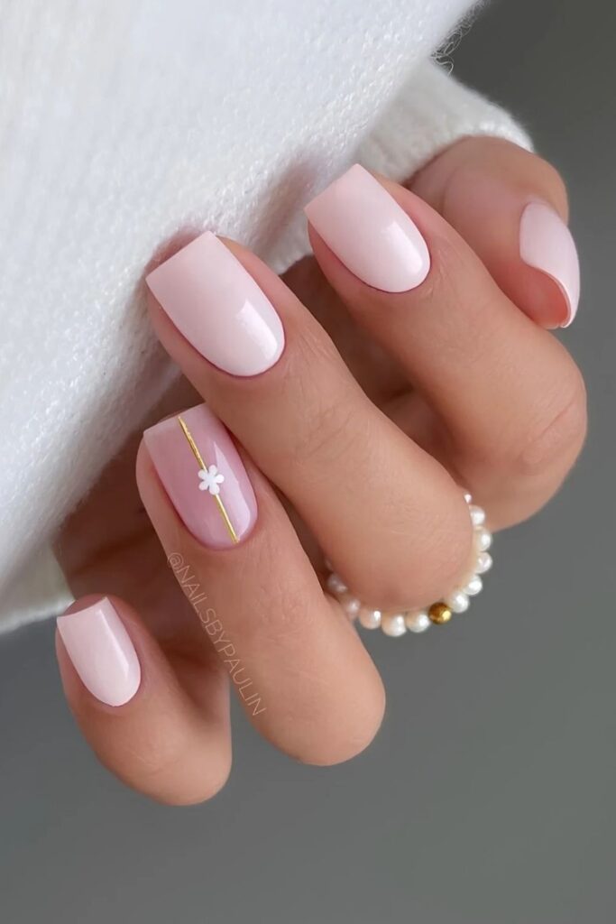 Light pink nails with floral accent and gold line