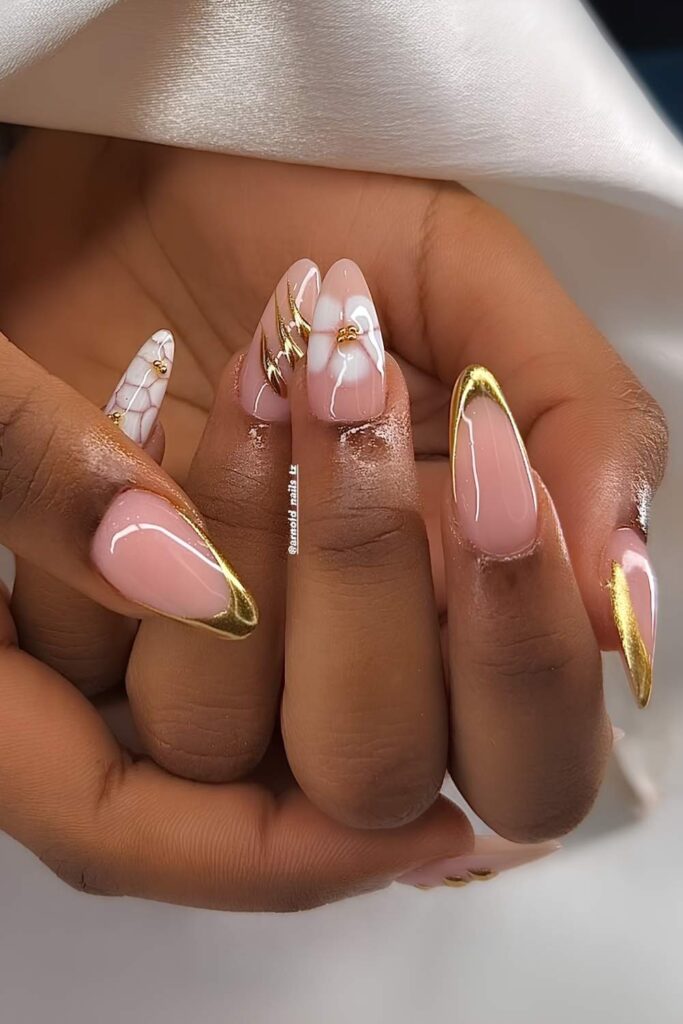 Sheer almond nails with gold chrome and floral accents