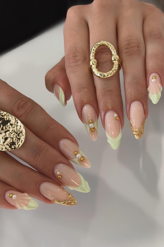 Light green French tip nails with gold chrome accents