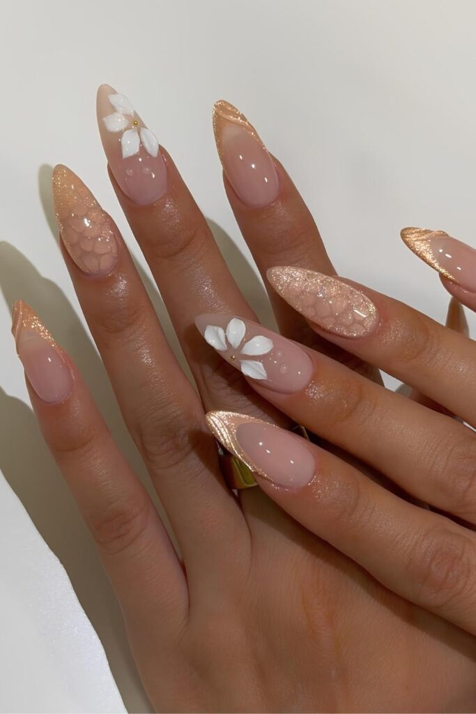 Shimmery gold nails with cat-eye effect and floral accent