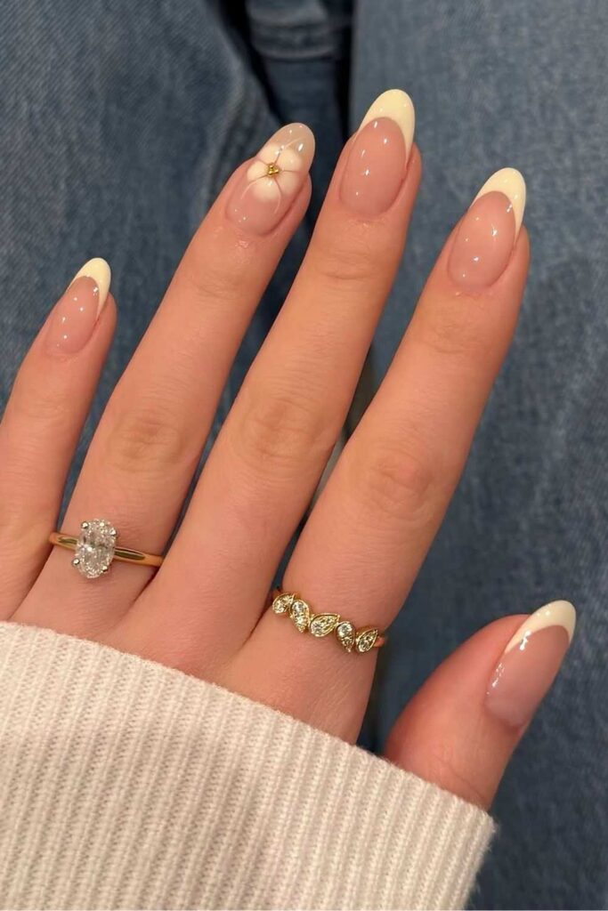 Butter yellow French nails with blooming flower