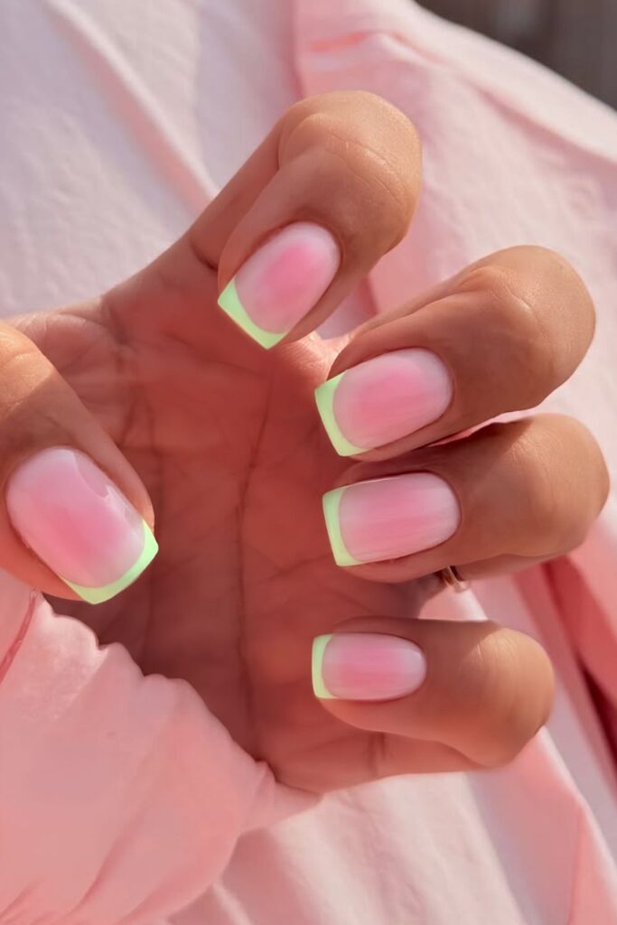 Light green French nails with pink aura effect
