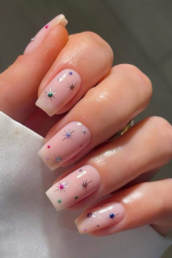 Milky pink nails with gems and stars