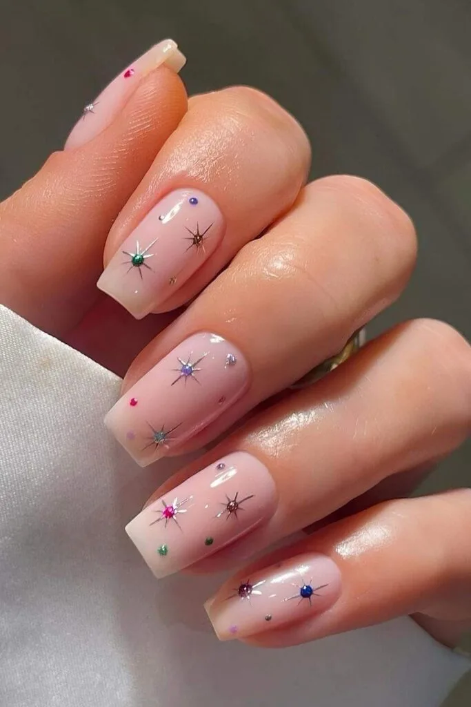 Milky pink nails with gems and stars