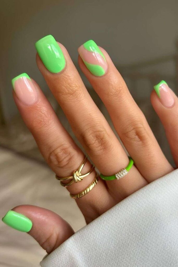 Neon green nails with French tip accent and swirly detail