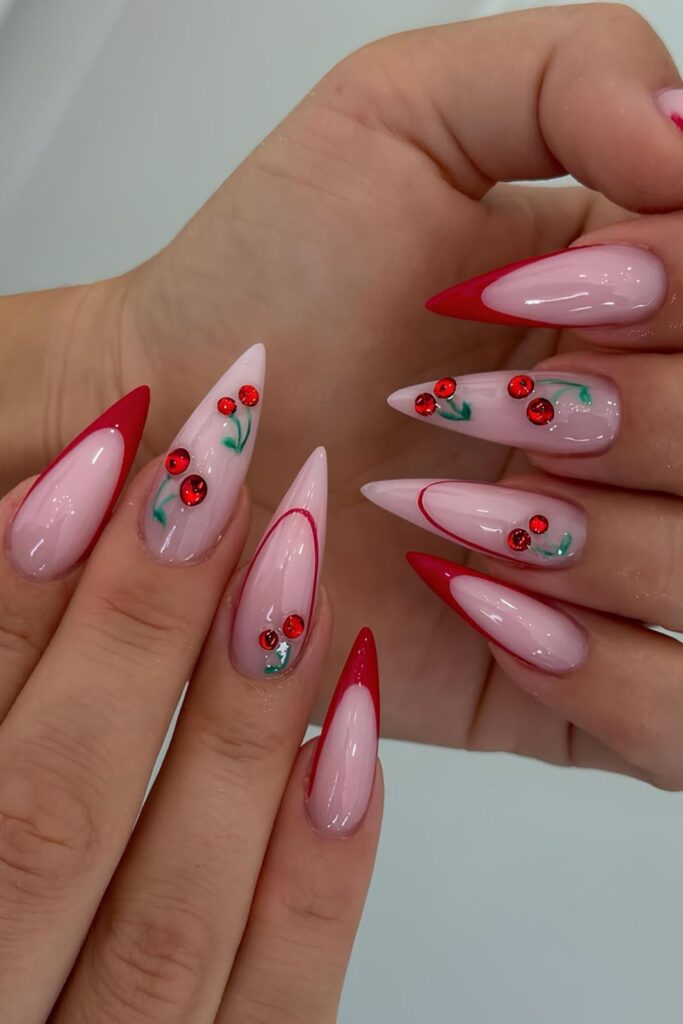 Red stilleto French nails with cherry rhinestone accents