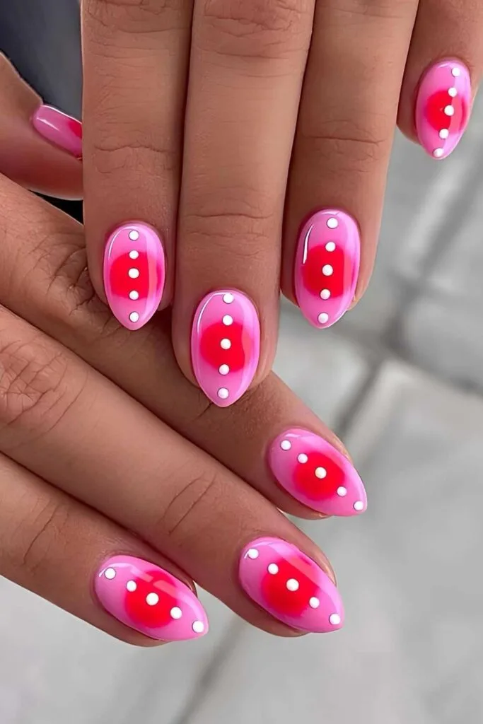 Neon pink nails with red aura and white dots