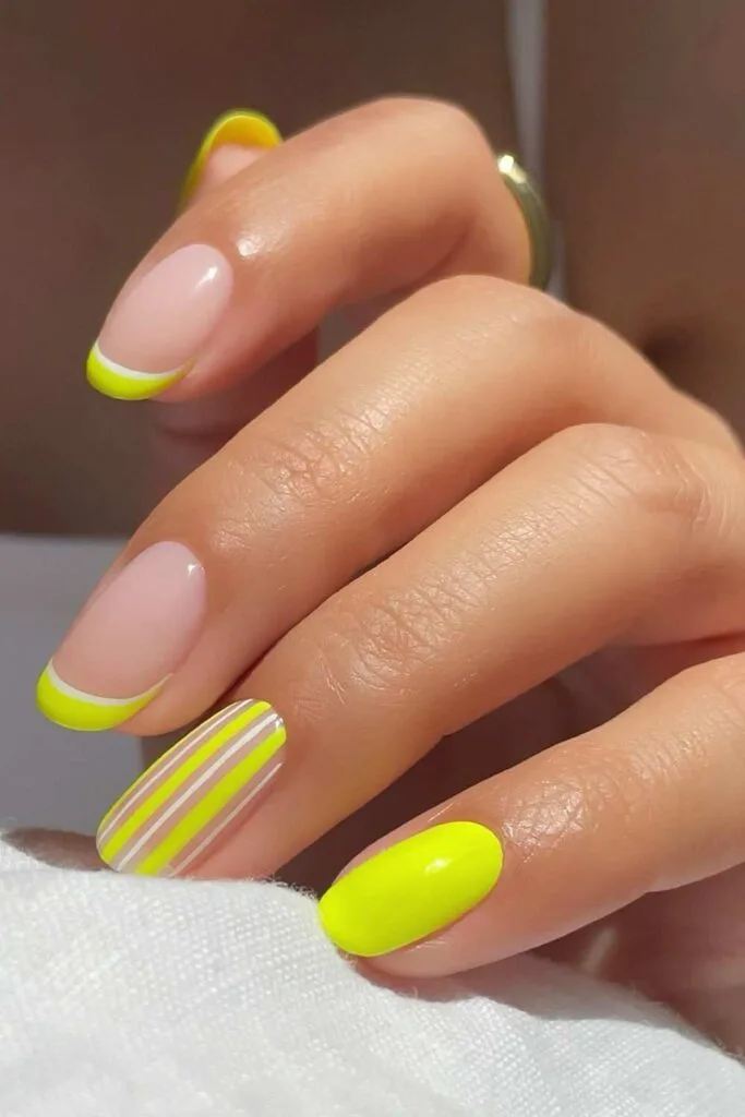 Neon yellow nails with stripes and French tip accent