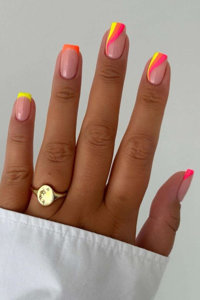 Neon yellow, orange and pink nails with swirls and French tips