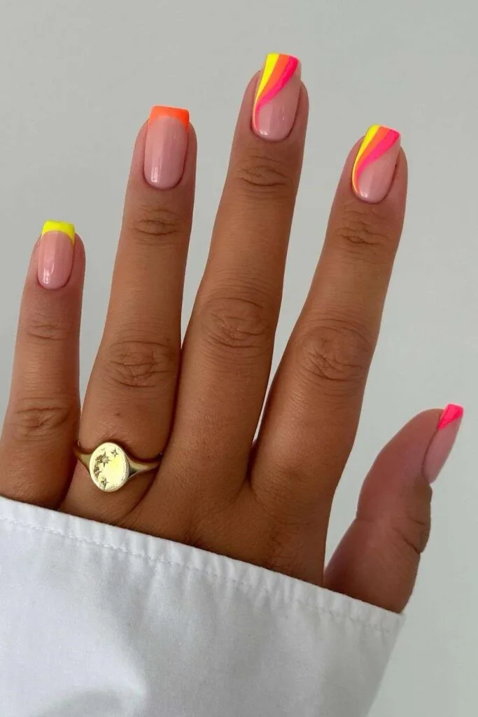 Neon yellow, orange and pink nails with swirls and French tips