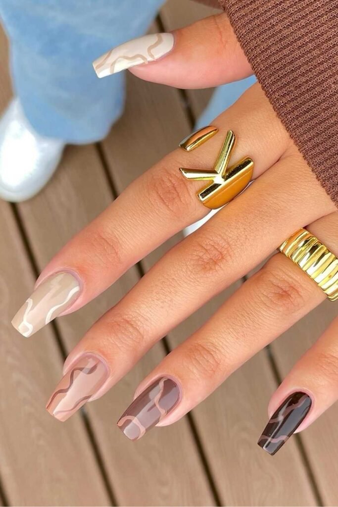 Brown skittle nails with swirls