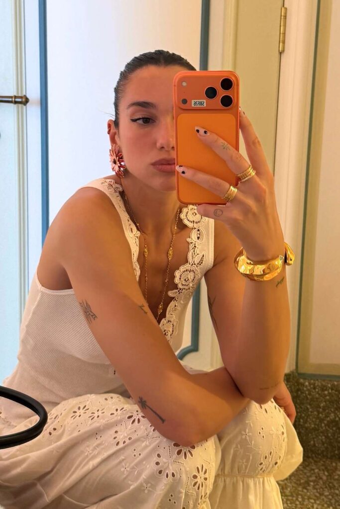 Dua Lipa showing her xl black polka dot manicure in a mirror selfie