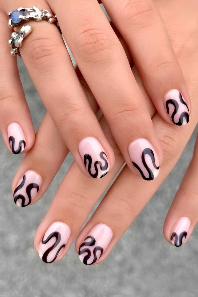 Neutral glossy nails with black bold swirls