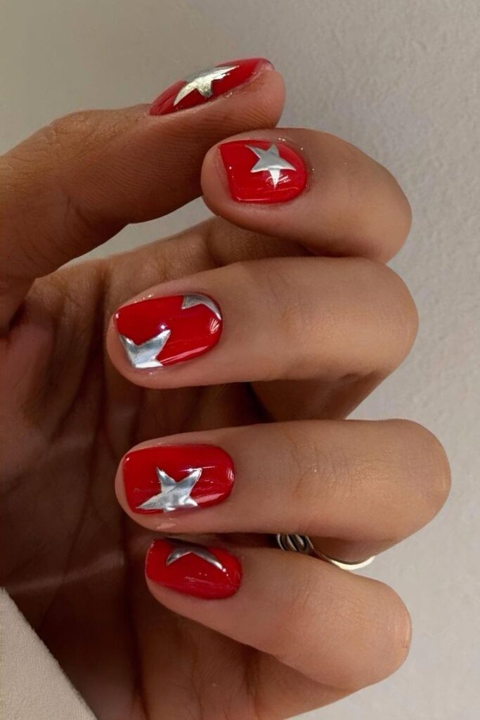 Short red nails with silver chrome stars