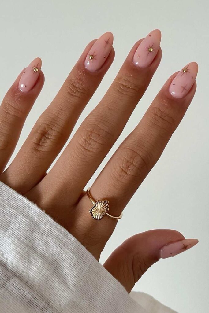 Soft pink nails with tiny gems and stars