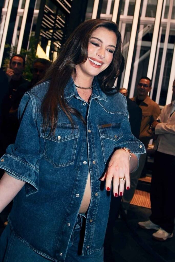 Anne Hathaway wearing red manicure with denim outfit