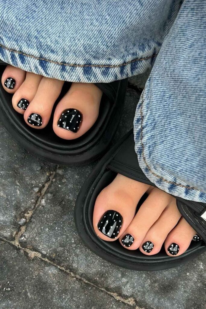 Black pedicure with white polka dots