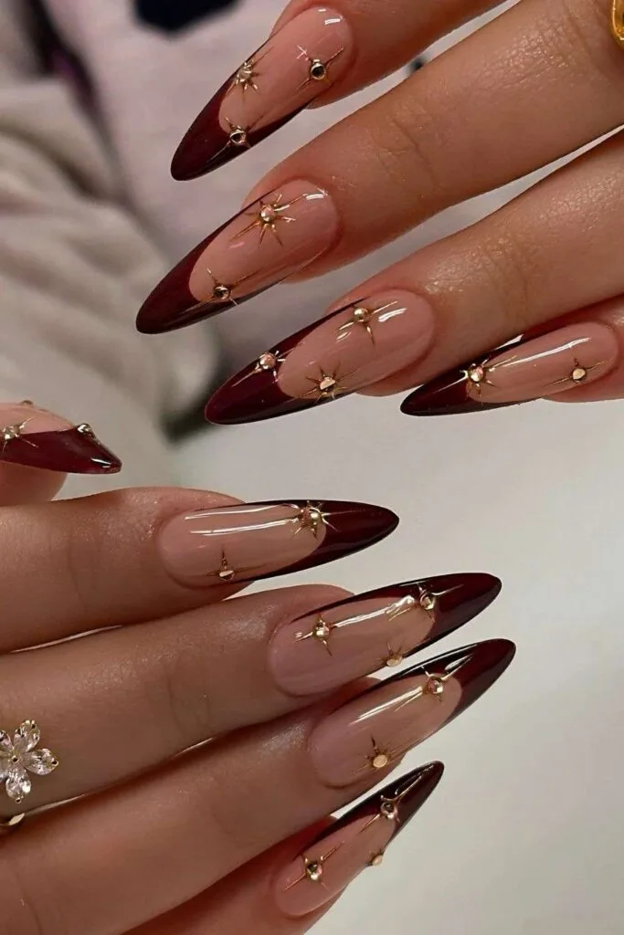 Burgundy French nails with gold celestial accents
