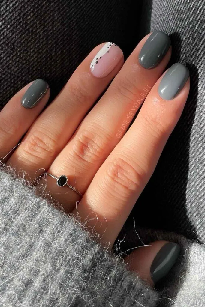 Dark gray nails with sheer accent nails and white line with tiny dots
