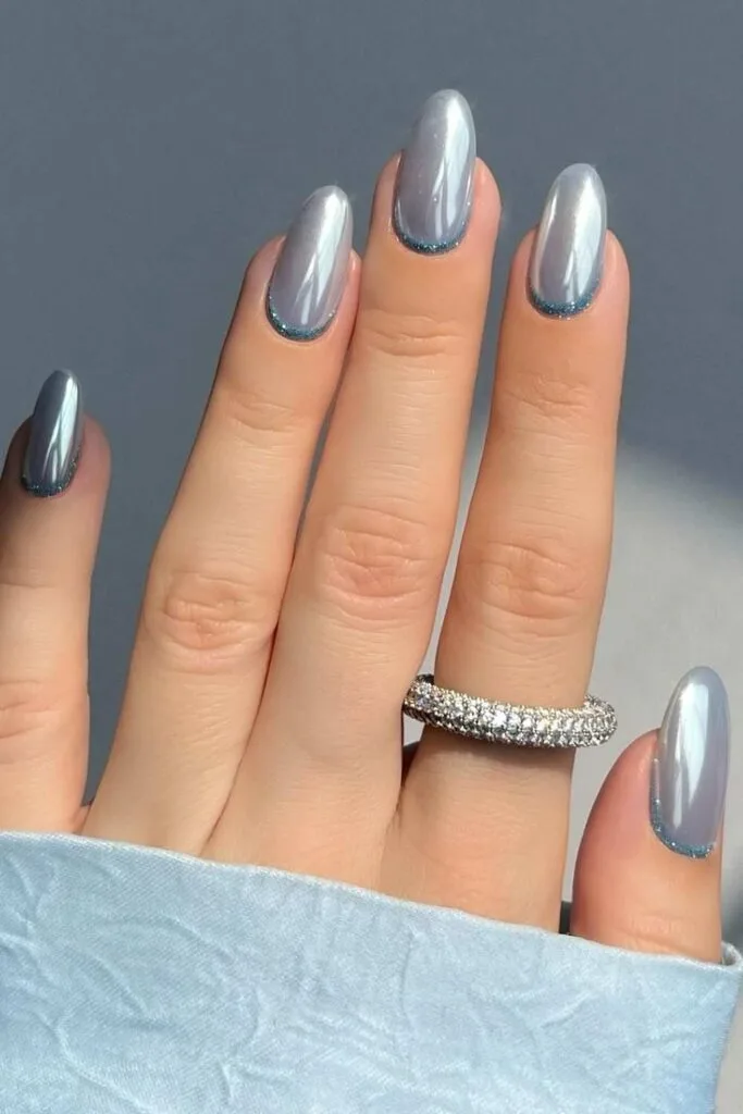 Icy blue chrome nails with glitter on cuticles