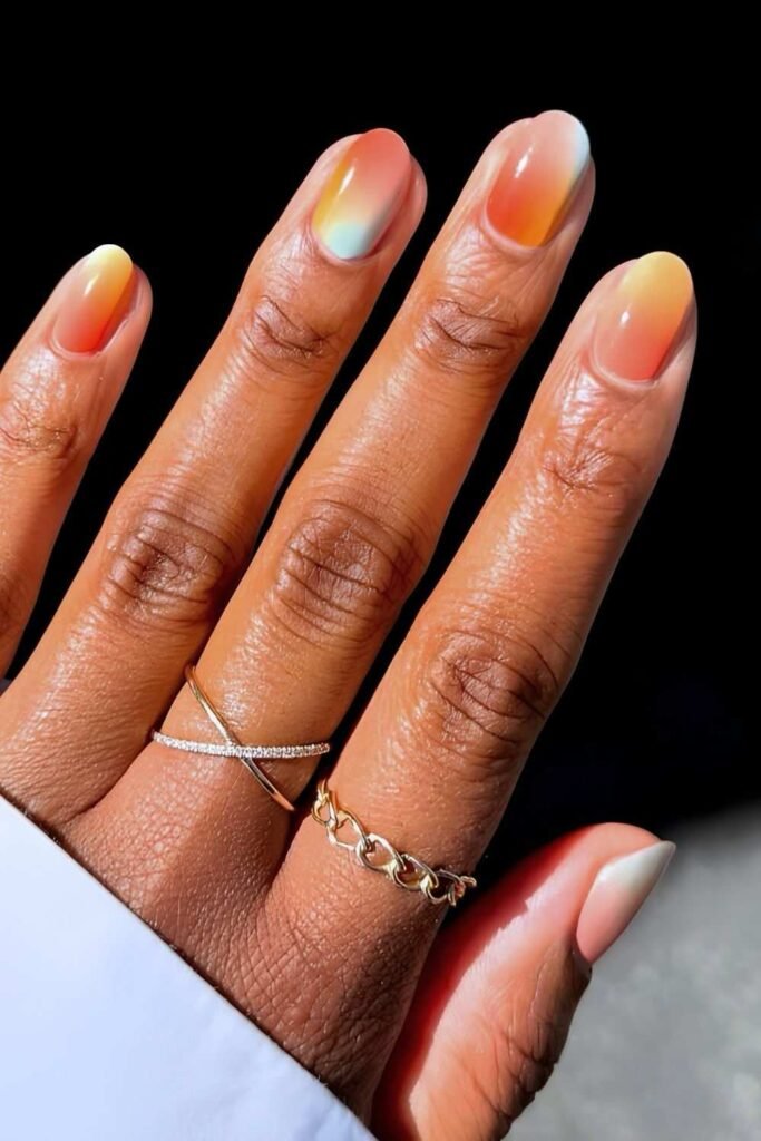 Peach and orange sorbet aura nails with a soft blurred gradient