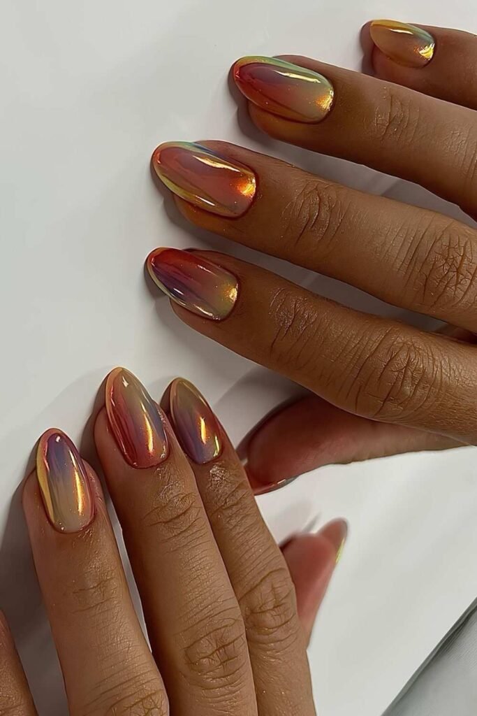 Peach and pink sorbet chrome nails with an iridescent finish