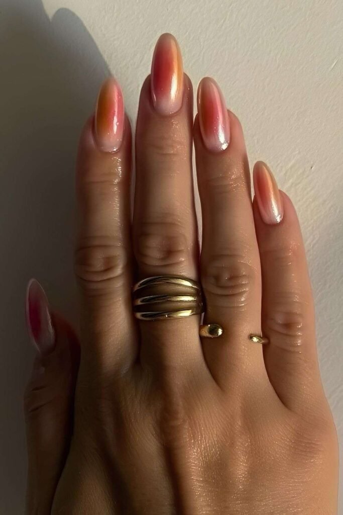 Pink and peach aura nails with a pearlescent chrome glow