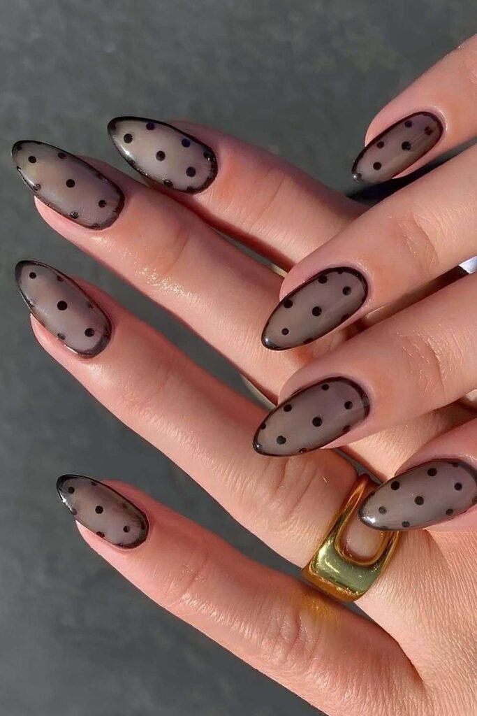 Sheer black nails with black polka dots