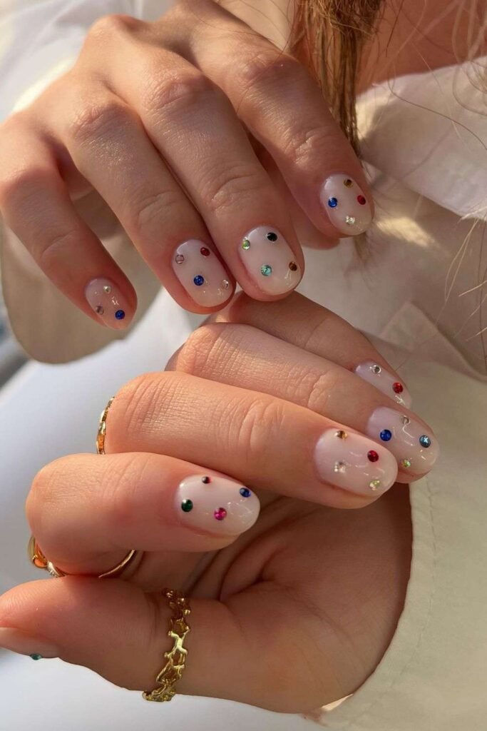 Short milky nails with colorful gems