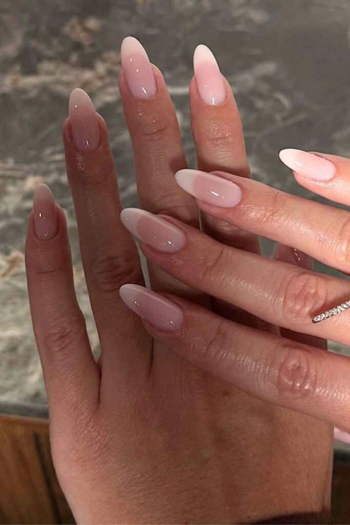 Glossy almond nails with subtle milky white French tips