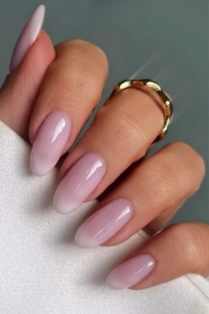 Glossy milky pink nails with subtle white tips on almond nails