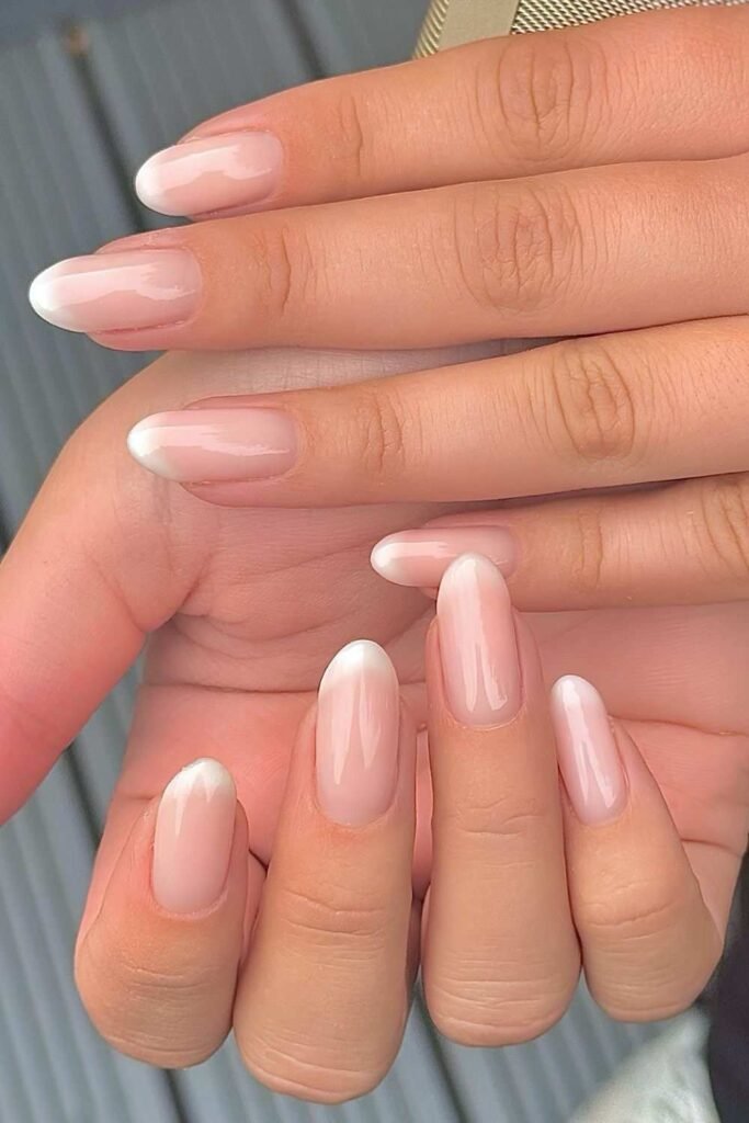 Glossy pink foggy French nails with soft white tips on oval and almond shape