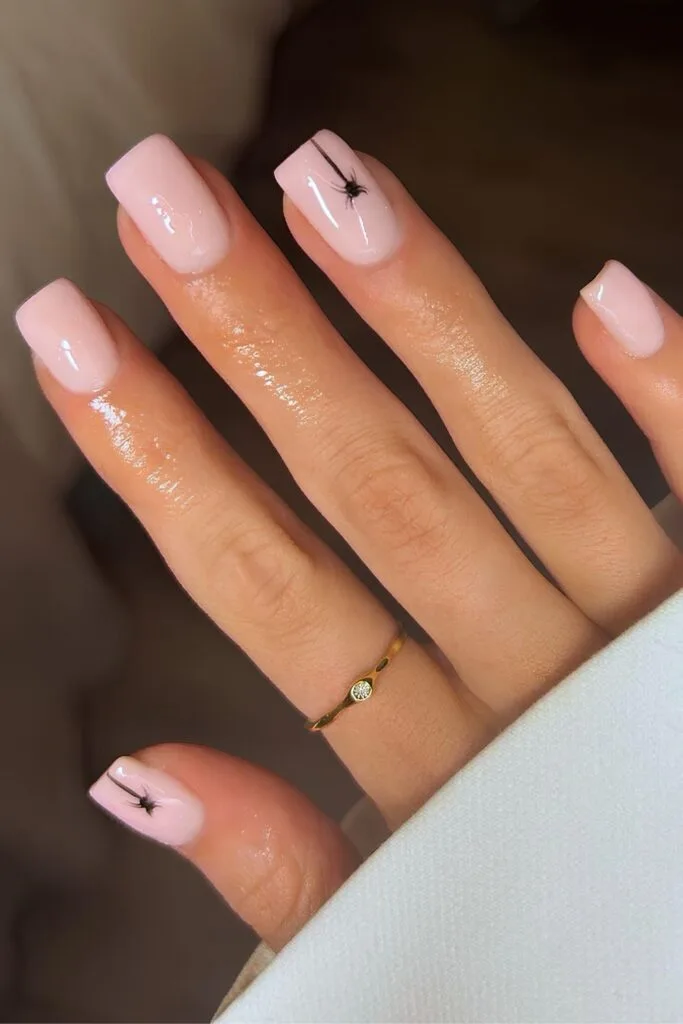 Milky pink nails with black spiders