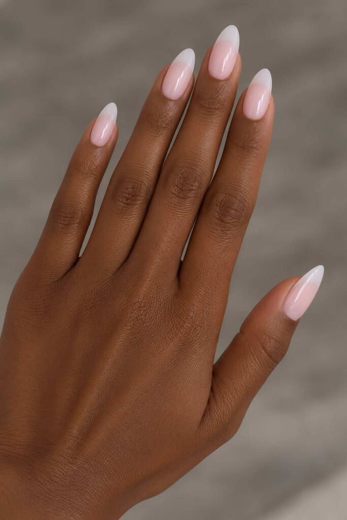 Sheer pink almond nails with softly faded white tips