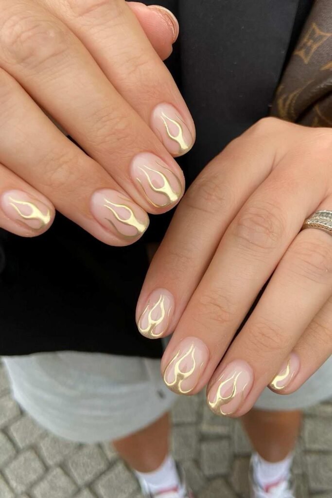 Short natural nails with golden metallic flames